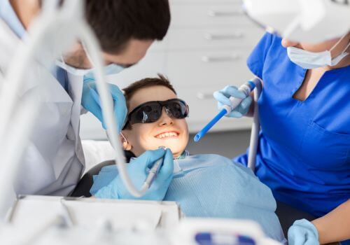 Young boy at dentist learning about laser dentistry.