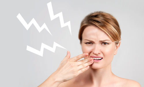 Emergency dentist photo 1 woman holding mouth